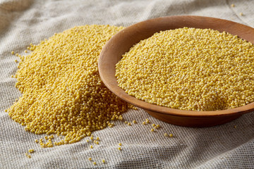 Two bowls of millet on a wooden background, top view, close-up, selective focus.
