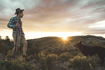 Mountaineer with his dog in the mountains. Concept of adventure and freedom