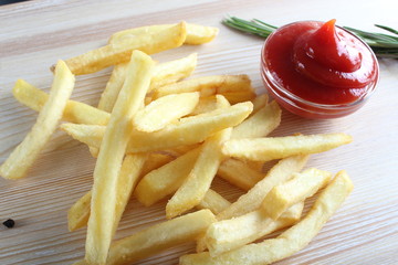 french fries and ketchup on a light wood background