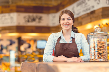 Attractive baker in uniform at the counter