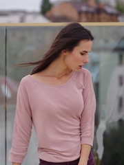 Pretty young woman posing near a glass wall