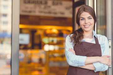 Smiling owner in uniform in the bakery