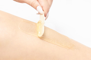 Sugar hair removal from woman body. Wax epilation spa procedure. Procedure beautician female. Leg