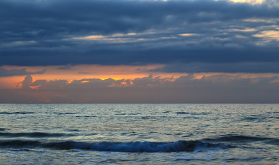 Obraz premium Nature in twilight period which including of sunrise over sea. Summer beach with blue water and purple sky at the sunset.