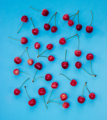 Obraz na płótnie Canvas Red cherries on a blue background - summertime