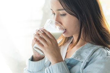 close up view of woman drinking a glass of milk in morning