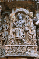 Fototapeta na wymiar Ornate wall panel reliefs depicting Bhairava, a form of Shiva, Kedareshwara temple, Halebidu, Karnataka