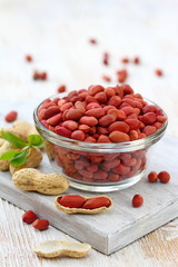Peanut in a bowl on wooden table.