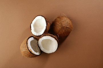 Halves of coconuts on brown background