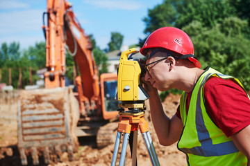 surveyor worker with theodolite at construction site