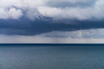 dense rain clouds and a tornado over the sea