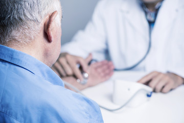 doctor measuring the blood pressure of a senior