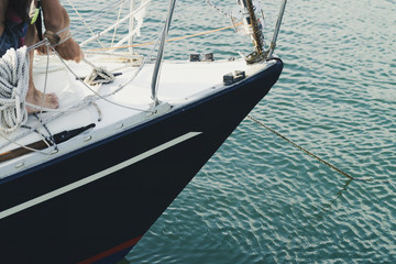Fototapeta premium man pulls the cables to anchor the yacht in the port