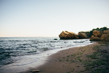 sea shore with rocks and waves on the sunset
