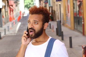 Shocked young man on the phone 