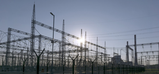 industrial landscape - different structures of an electrical substation in a backlight