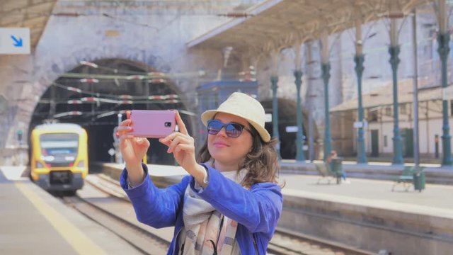 Young woman tourist taking pictures of Sao Bento Railway station
