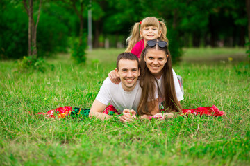 Fototapeta premium happy young family spending time outdoor on summer day. Happiness and harmony in family life. Family fun outside.