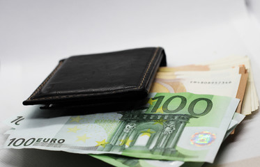 Money in your wallet. Denominations look out of the purse. Paper euros.