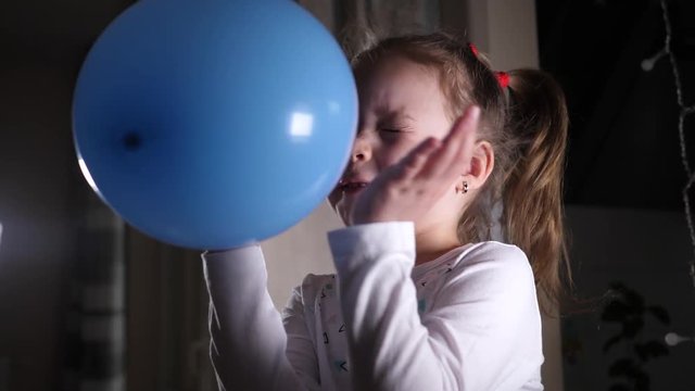 Little cute girl daughter play at home with blue balloon releasing it for fly away