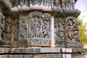 Ornate wall panel reliefs depicting from left Harihara, Arjuna shooting arrow at the fish, a drumer, and dancing Shiva, Kedareshwara temple, Halebidu, Karnataka