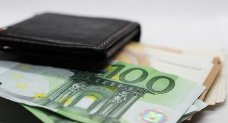 Money in your wallet. Denominations look out of the purse. Paper euros.
