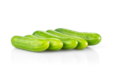 Five fresh green mini cucumbers in row isolated on white background.