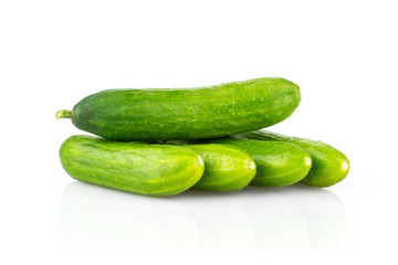 Five fresh green mini cucumbers isolated on white background.