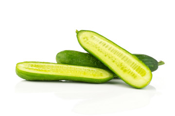 One fresh green mini cucumber and two section halves isolated on white background.