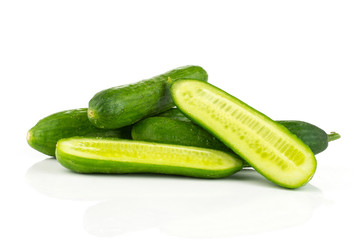 Fresh green mini cucumbers stack and two section halves isolated on white background.