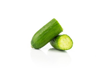 Sliced fresh green mini cucumber one cut in two halves isolated on white background.