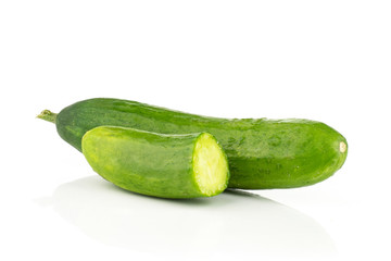 One fresh green mini cucumber with a half isolated on white background.