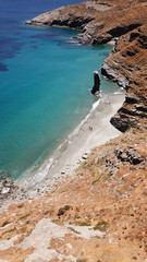 Aerial drone bird's eye view of iconic beach of Grias Pidima with giant rock rare geological formation and turquoise crystal clear waters, near village of Korthi, Andros island, Cyclades, Greece