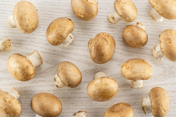 Fresh brown champignons top view on grey wood background raw mushrooms.