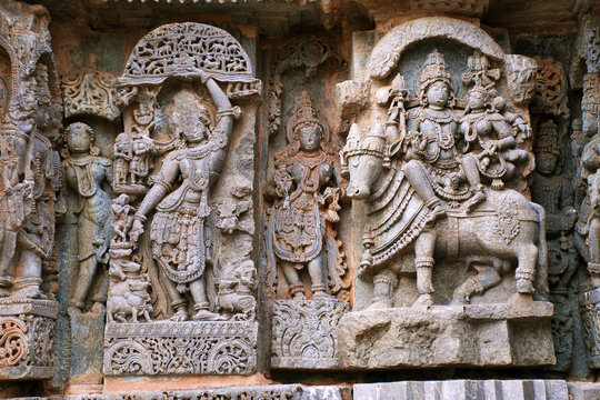 Ornate wall panel reliefs depicting From left Krishna as Govardhan Giridhari and Shiva-Parvati seated on Nandi, Kedareshwara temple, Halebidu, Karnataka