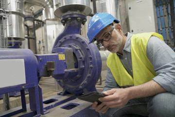 Fototapeta na wymiar Industrial technician connected with tablet in recyling plant