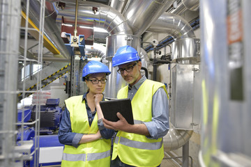 Industrial engineers working in recycling plant with tablet