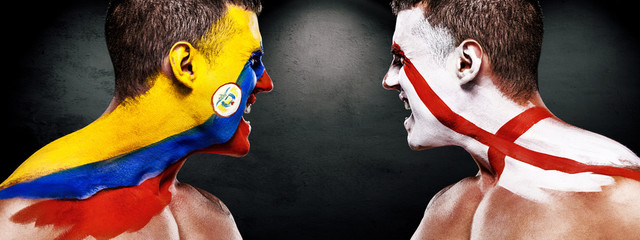 Soccer or football fan with bodyart on face with agression - flags of Colombia vs England.