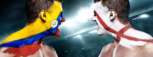 Soccer or football fan with bodyart on face with agression - flags of Colombia vs England.