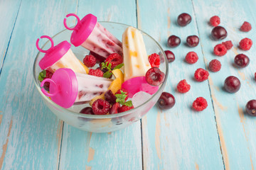 Homemade Eskimony from yogurt, in a plate ice cream on sticks, top view, flat lay with empty space for an inscription. Right color, summer mood.