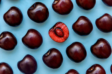 picture of a bright burgundy cherry on a blue background.