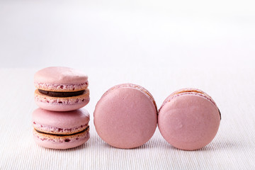 Heap of pink macaroons - French cookies on white table.