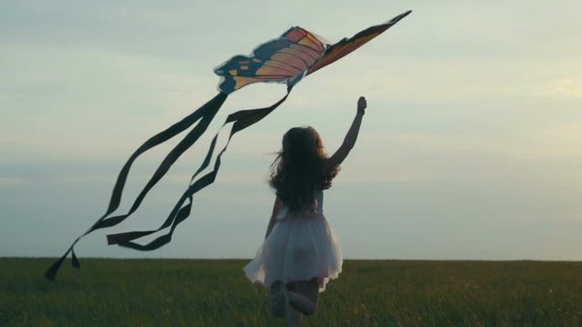 girl running around with a kite on the field. Freedom concept.
