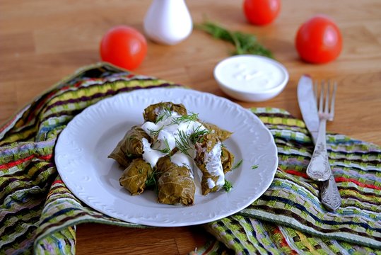 Dolma / Sarma, a traditional Armenian dish, minced meat with rice and spices in grape leaves.Served with natural yogurt and garlic sauce