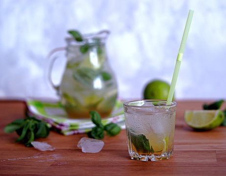 Cold summer drink, lemonade with lime and basil on the basis of sparkling water and sugar syrup. Served with ice. Summer concept.