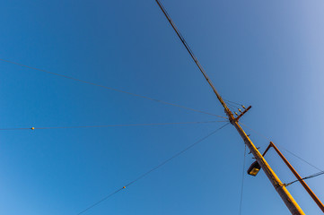 An electric post with wires with blue cloudy sky background