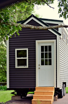 Tiny gray house on wheels in a closeup portrait view