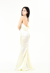 Fototapeta na wymiar Bride, graceful girl in dress. Fashion model demonstrate expensive fashionable evening dress or wedding dress. Fashion wedding concept. Woman in elegant white dress with nude back, white background.