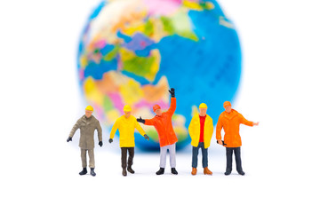 Miniature people, group of workers standing on mini planet background using as business, logistics and industry concept