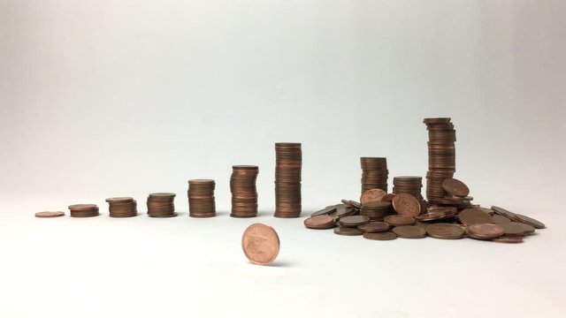 Moneda de centimo rueda hasta pararse, detras mas monedas .